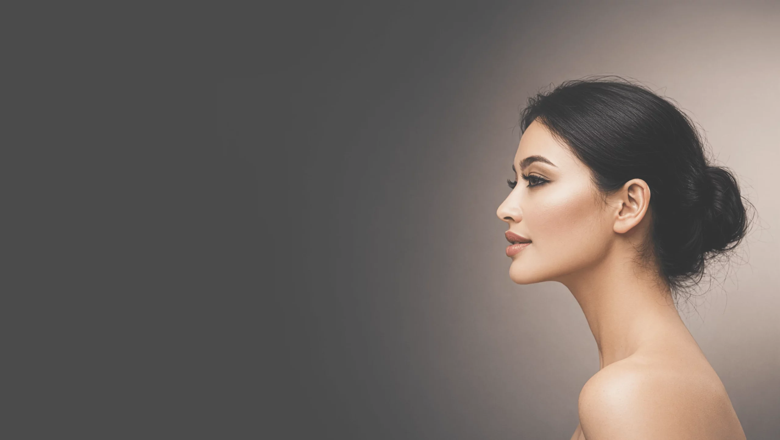 Woman in profile with dark hair gathered in a bun